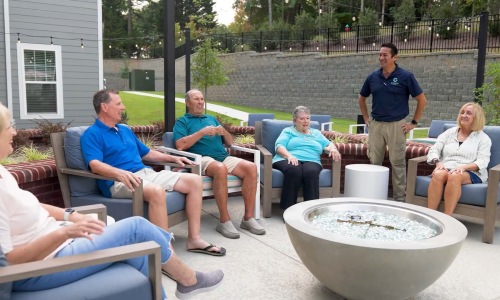 Arden at Huntersville - 55 + a group of people sitting around a fireplace