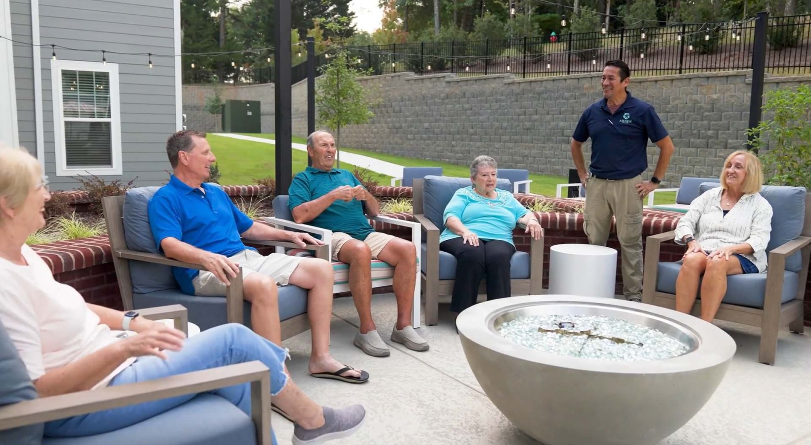Arden at Huntersville - 55 + a group of people sitting around a fireplace