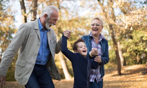 two grandparents walking with their grandson