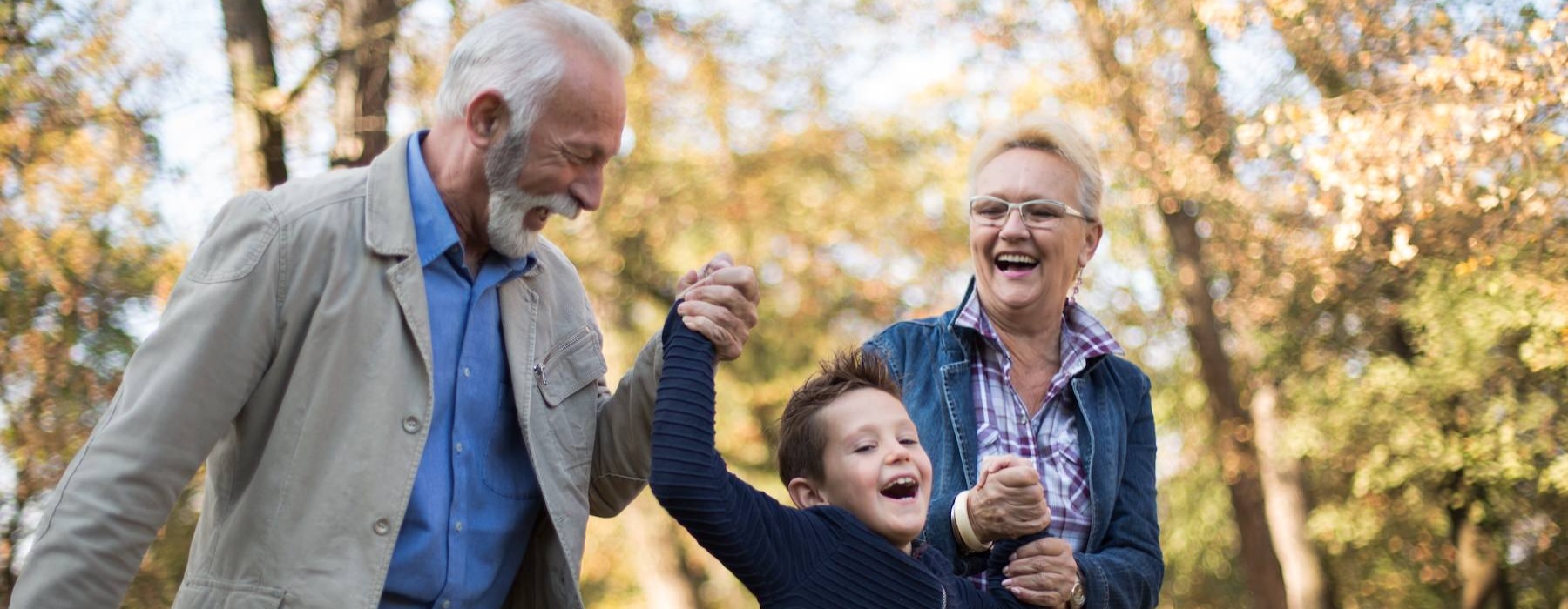 two grandparents walking with their grandson