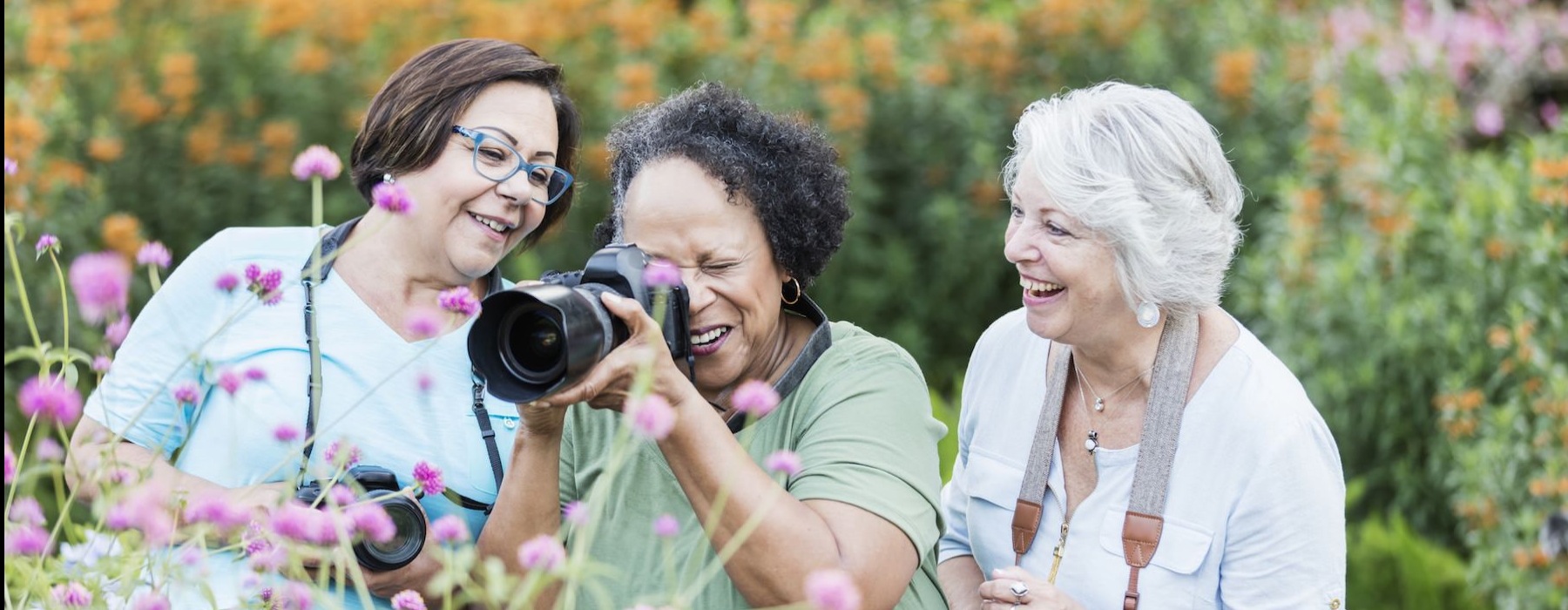 three friends taking photos of flowers